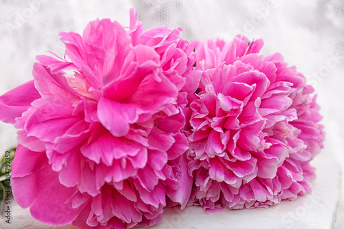 close-up beautiful bouquet with large flowers peonies  just cut  lies on a white stool against the backdrop of curtains. Romantic pink flower bouquet