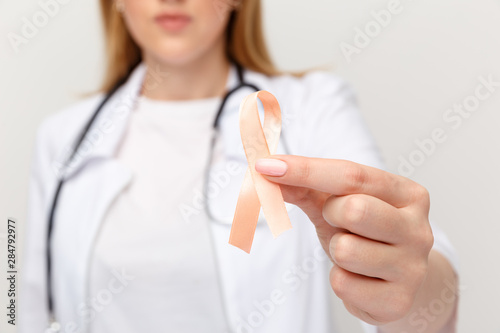 Orange ribbone in doctor's hand isolated photo