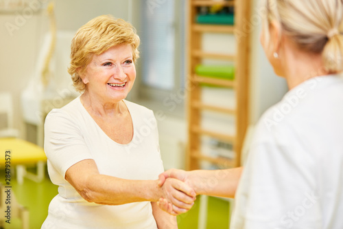 Glückliche Patientin begrüßt Hausärztin mit Handschlag photo