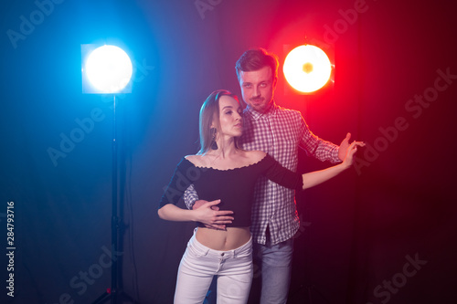 Social dance, kizomba, salsa, semba or zouk concept - a young couple dancing bachata and salsa at the disco photo