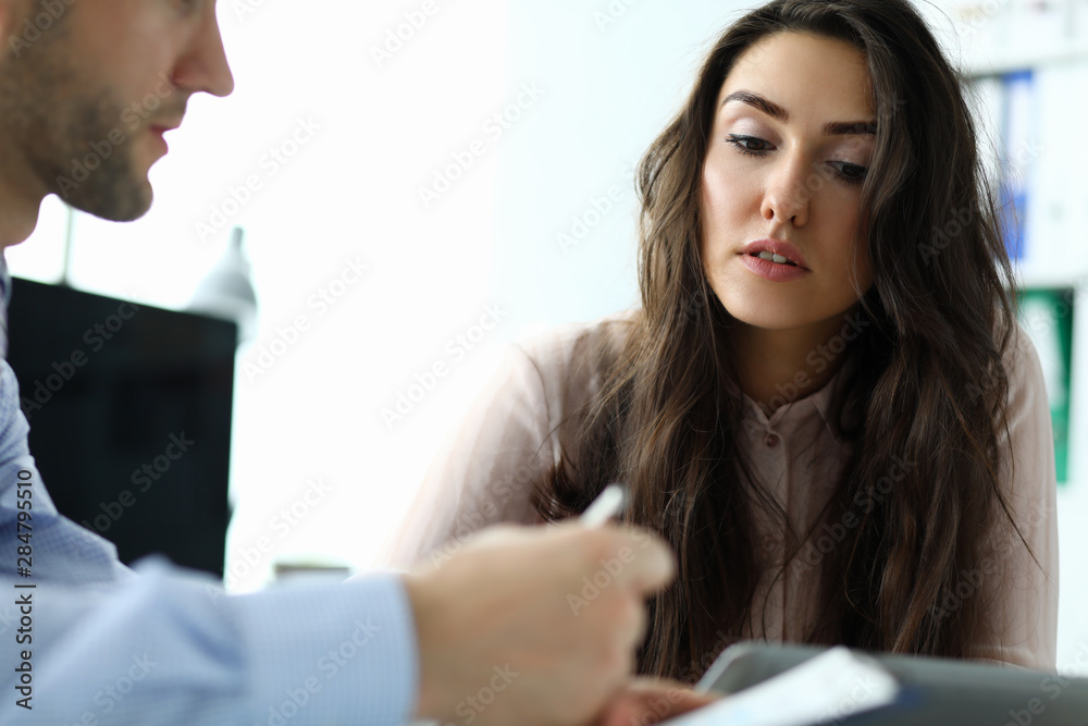Portrait of attractive businesswoman looking at important business paper. Smart man in blue shirt holding contract. Biz meeting concept. Blurred background Portrait of attractive businesswoman looking at important business paper. Smart man in blue shirt holding contract. Biz meeting concept. Blurred background