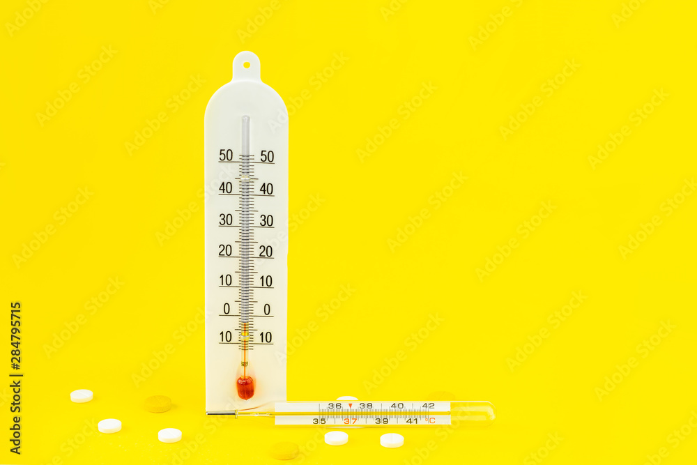 Treatment of colds and flu. Various medicines, a thermometer, sprays from a stuffy nose and a pain in a throat on a yellow background. Copy space.The concept of cooling and fever. Treatment of colds and flu. Various medicines, a thermometer, sprays from a stuffy nose and a pain in a throat on a yellow background. Copy space.The concept of cooling and fever.