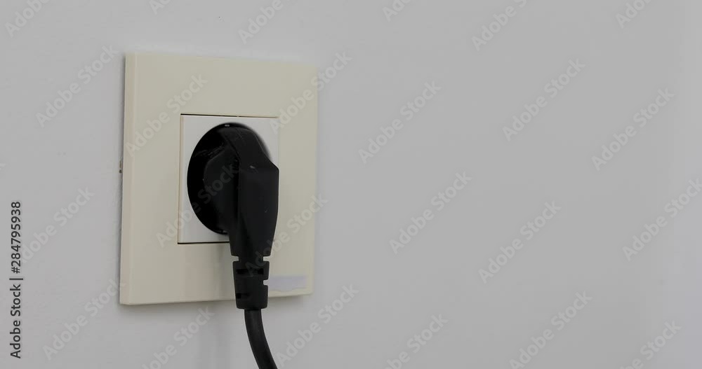 Female hand turn on off and plug unplug wires at home. Plugging multiple power plugs into wall outlet many different plugs