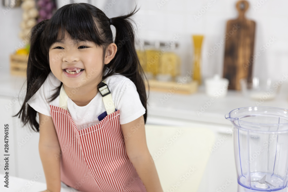 Portrait of Happy Asian Little girl smiling in Apron set cooking food in kitchen at home. Portrait of Happy Asian Little girl smiling in Apron set cooking food in kitchen at home.