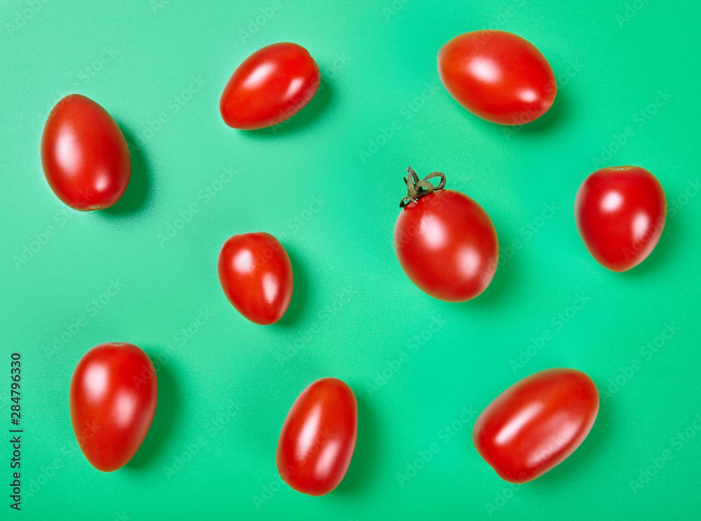 Red cherry tomatoes on green background. Top view. Red cherry tomatoes on green background. Top view.