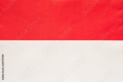 Monaco national fabric flag, textile background. Symbol of international world european country.