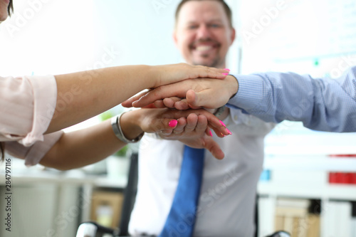 Focus on folded hands of colleagues on each other. Managers underwriting good deal and celebrating closing bargain. Business meeting and teamwork concept