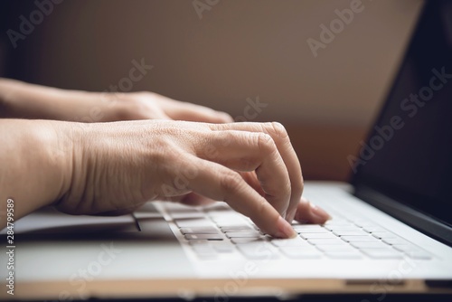 Lady finger touch or press laptop keyboard  - people working with technology concept