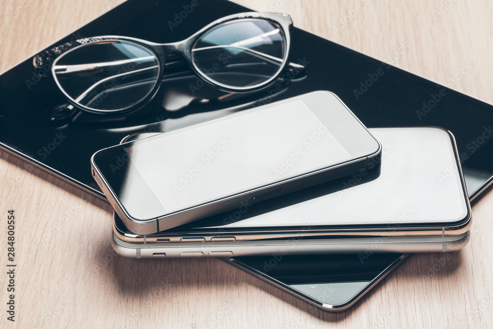 Digital tablet and mobile phone. Electronic devices on wooden table, close up. Digital tablet and mobile phone. Electronic devices on wooden table, close up.
