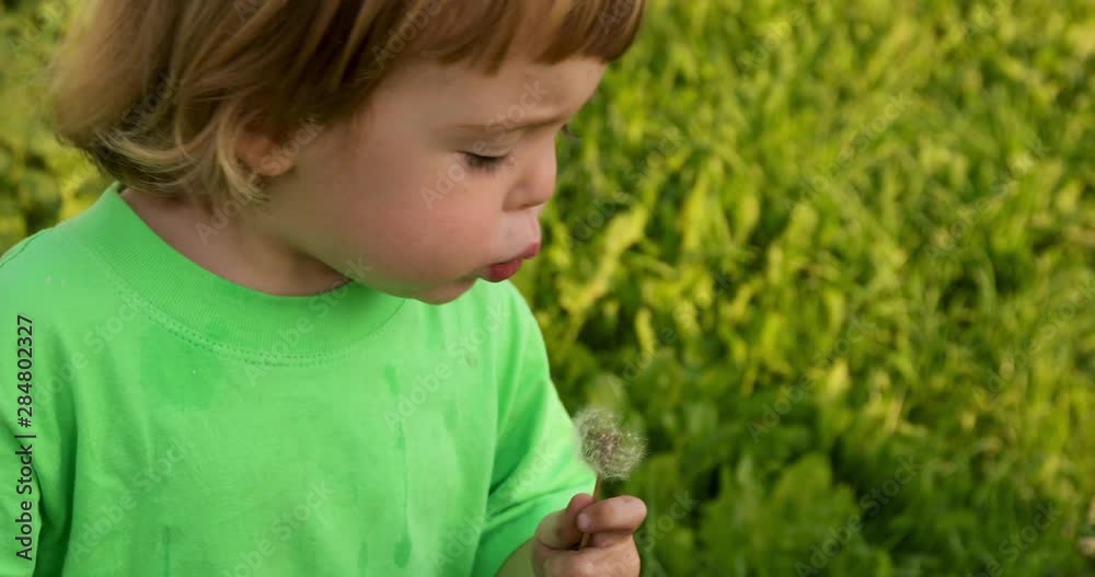 Little child with blowing dandelion. Spring outdoors background Little child with blowing dandelion. Spring outdoors background
