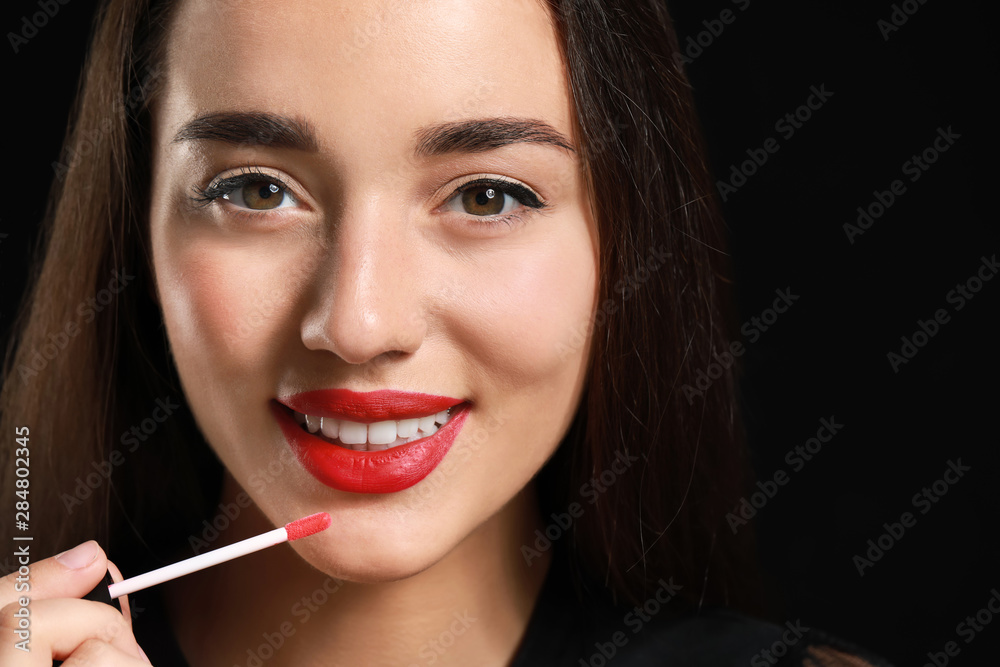 Beautiful young woman with bright lipstick on dark background Beautiful young woman with bright lipstick on dark background
