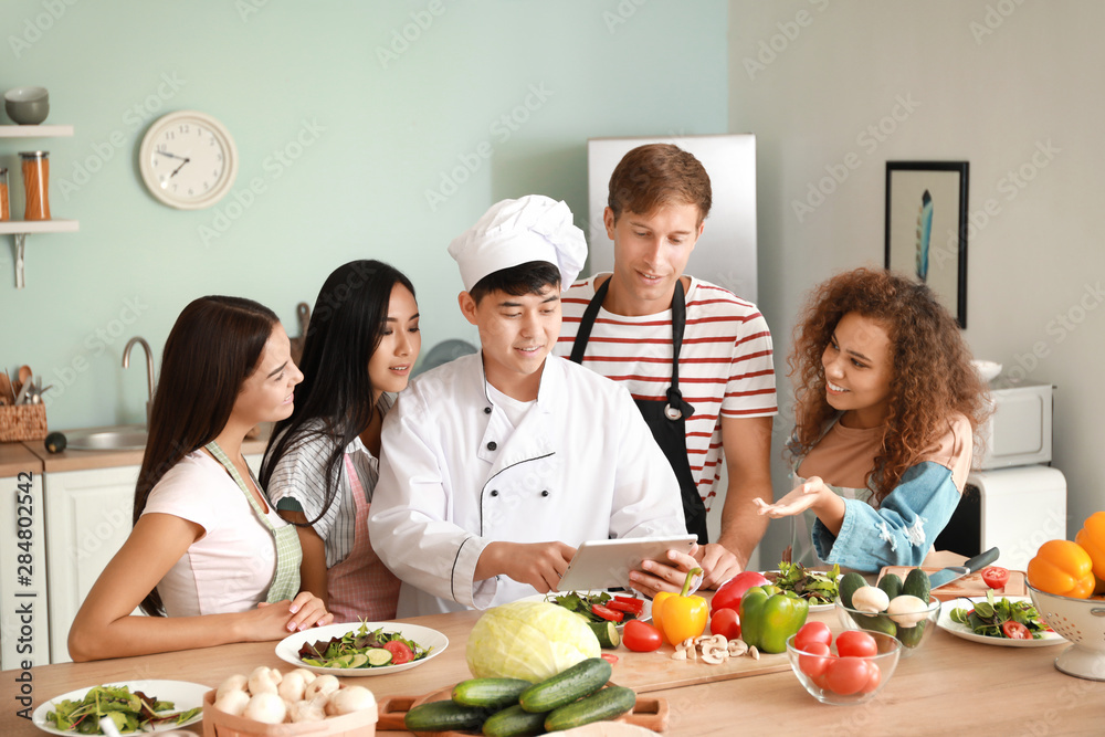 Asian chef and group of young people during cooking classes