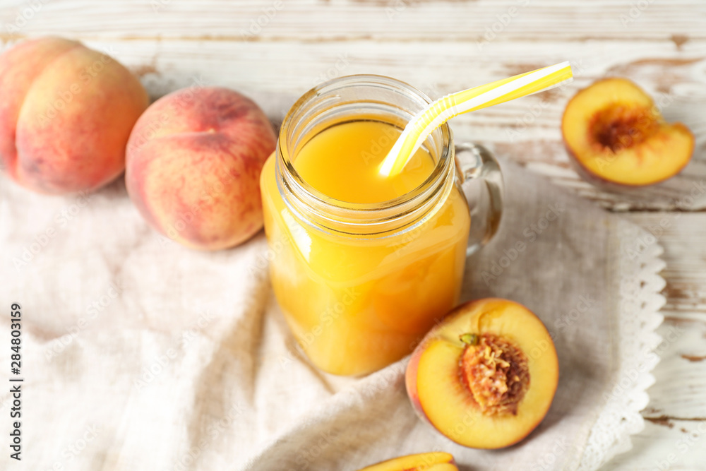 Mason jar of tasty peach juice on table Mason jar of tasty peach juice on table