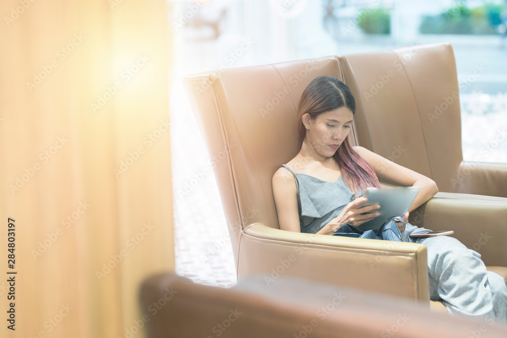 Young asian woman struggle with digital tablet, Frustrated asian girl looking at digital tablet while lying on sofa, People struggle with technology ,lady business woman got headache and depression. Young asian woman struggle with digital tablet, Frustrated asian girl looking at digital tablet while lying on sofa, People struggle with technology ,lady business woman got headache and depression.
