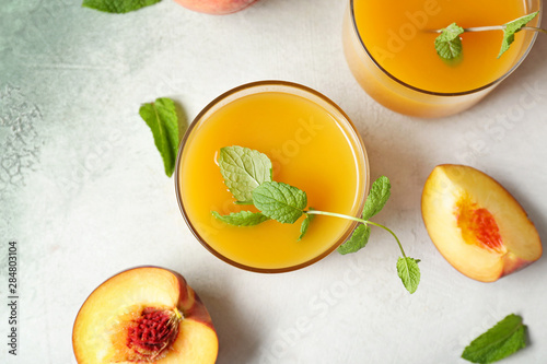 Fototapeta Naklejka Na Ścianę i Meble -  Glasses of tasty peach juice on light background