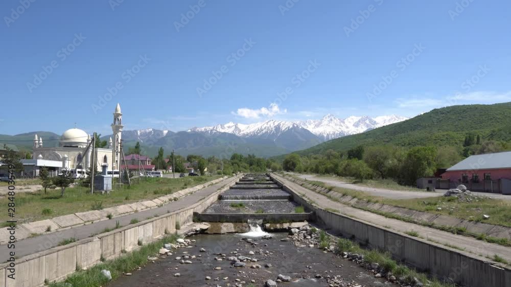 Esik Issyk River Streaming out from the Snow Capped Mountains at the Background with Central Mosque View on a Sunny Blue Sky Day Esik Issyk River Streaming out from the Snow Capped Mountains at the Background with Central Mosque View on a Sunny Blue Sky Day