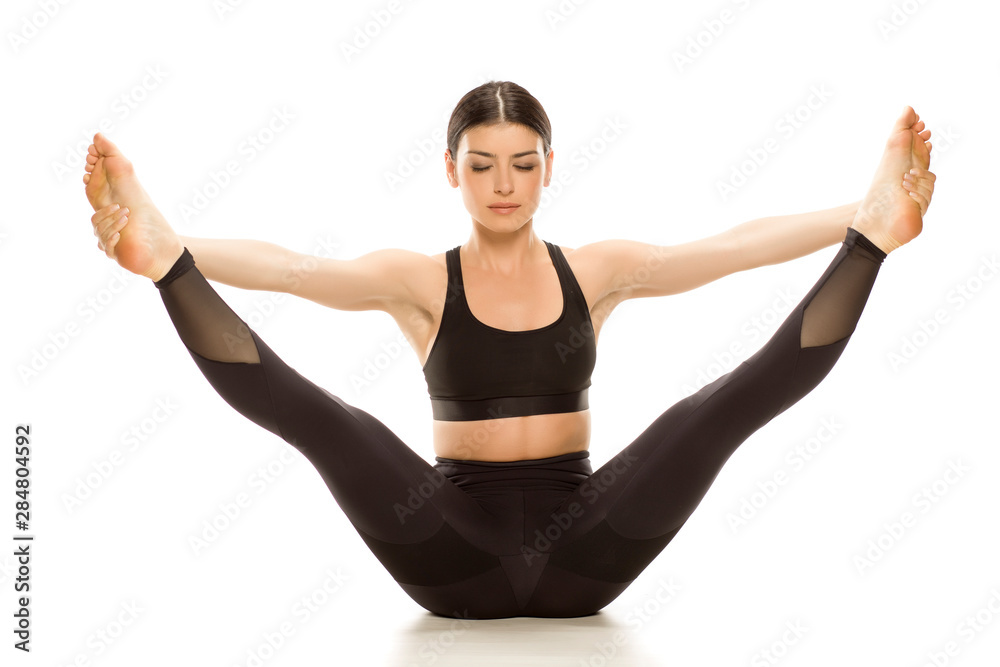 Young flexible yoga woman doing legs up exercise. Isolated on white  background. Stock Photo