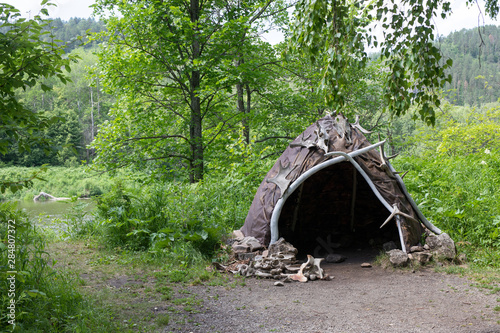 Hut or hovel made of animal skins and bones. Reconstruction of the human home of the Stone Bronze Age. On beautiful summer background.