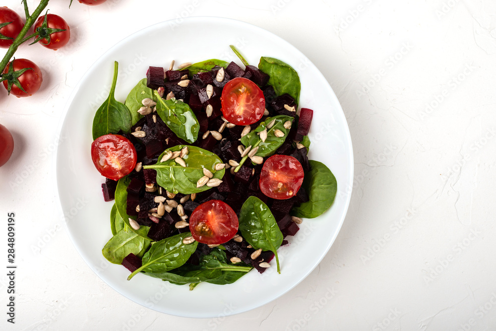 Healthy vegetarian food. Salad with beetroot, spinach, cherry tomatoes and seeds. Healthy vegetarian food. Salad with beetroot, spinach, cherry tomatoes and seeds.