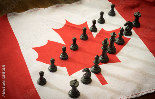 Black chess pieces on Canada flag.