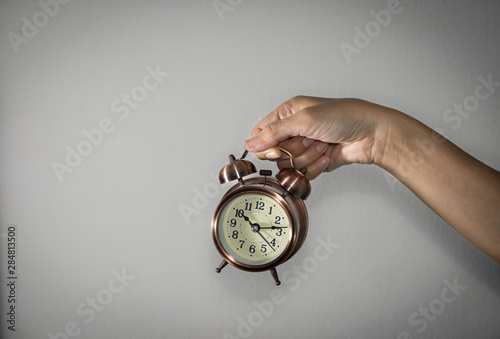 Alarm clock in female hand.