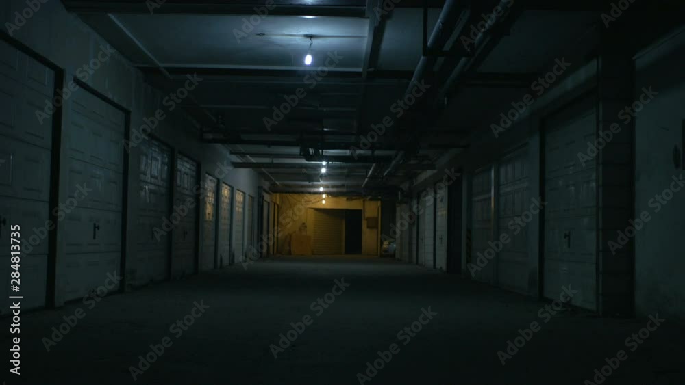 A big dirty parking garage under the flickering lights A big dirty parking garage under the flickering lights