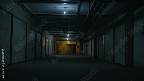 A big dirty parking garage under the flickering lights