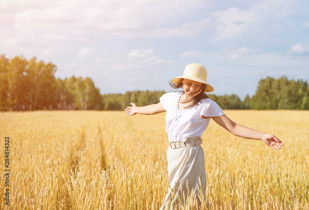 young beautiful woman in golden wheat field. concept of summer, freedom, warmth, harvest, agriculture