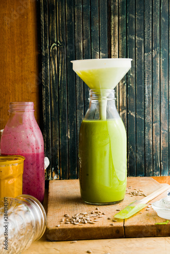 Green pea, pumpkin, and beetroots soup on a bottle on a rustic environment photo