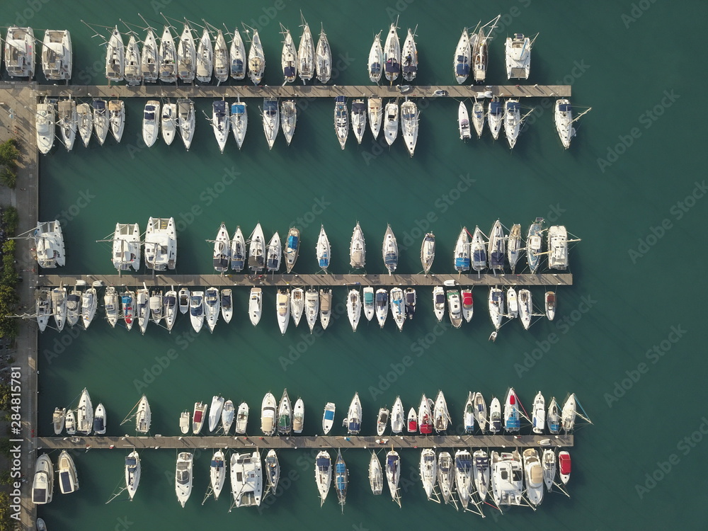 Aerial top view of boats and yachts in marina from above. Yacht parking, A marina lot, Yacht and sailboat is moored at the quay, Aerial view by drone. Lefkada island Aerial top view of boats and yachts in marina from above. Yacht parking, A marina lot, Yacht and sailboat is moored at the quay, Aerial view by drone. Lefkada island