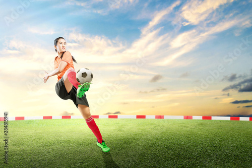 Asian football player woman kicking the ball
