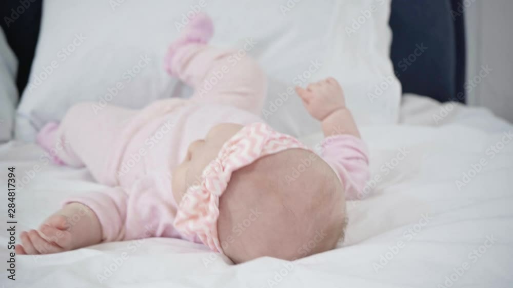 selective focus of adorable infant rolling over on bed selective focus of adorable infant rolling over on bed