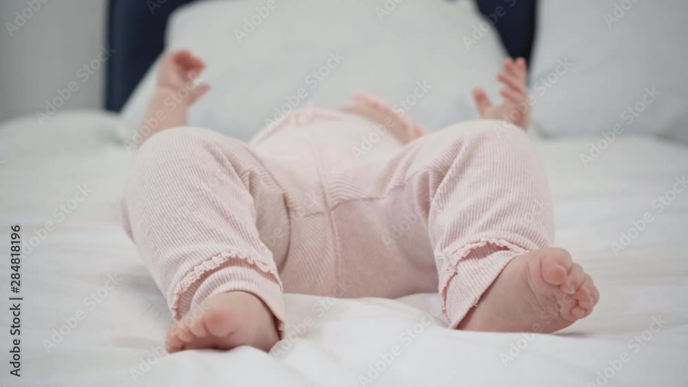 selective focus of cute infant moving feet on bed 