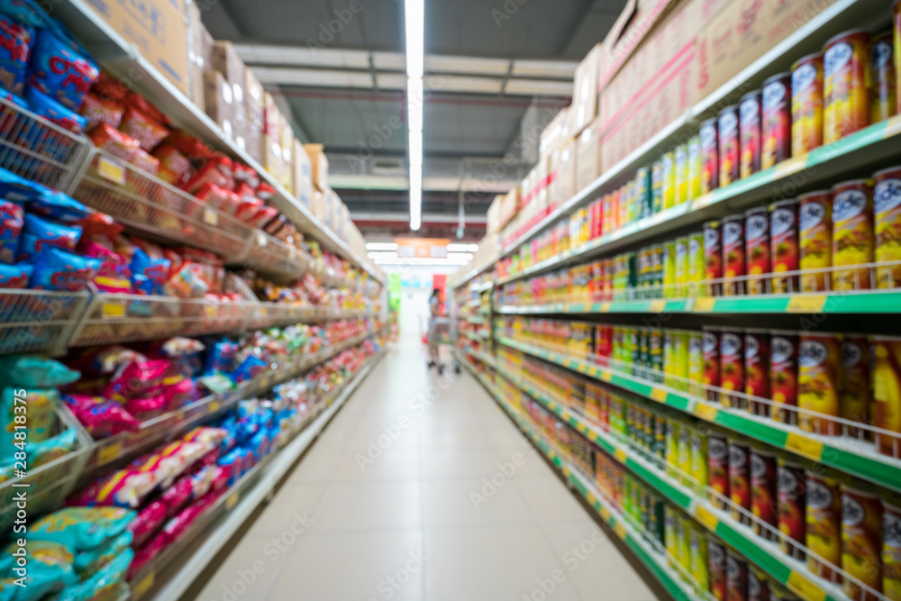 Supermarket blurred background with colorful shelves and unrecognizable customers