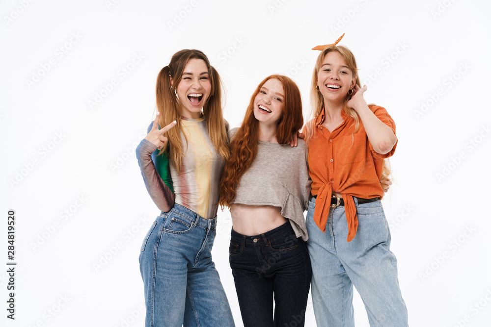 Obraz premium Portrait of three beautiful girls wearing casual clothes smiling and posing at camera together