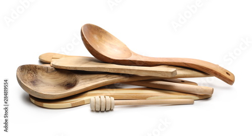 Wooden spoons, honey dipper and metal knife, kitchenware isolated on white background