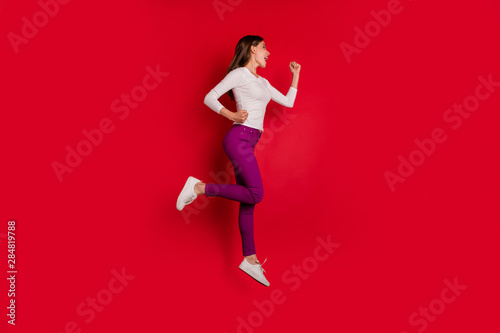 Full length body size photo of joyful encouraged nice cute girlfriend running towards shopping mall because there are discounts while isolated with red background