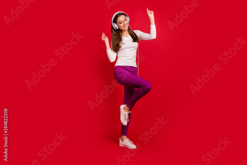 Full length body size photo of dancing girl imagining herself at disco while isolated with red background