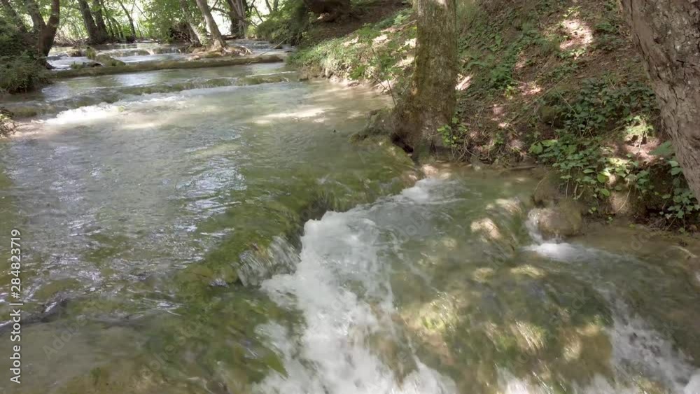 river with small waterfalls and lots of green foliage river with small waterfalls and lots of green foliage