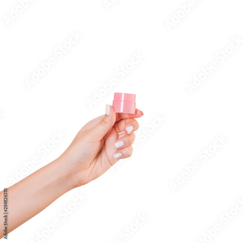 Female hand holding cream bottle of lotion isolated. Girl give jar cosmetic products on white background