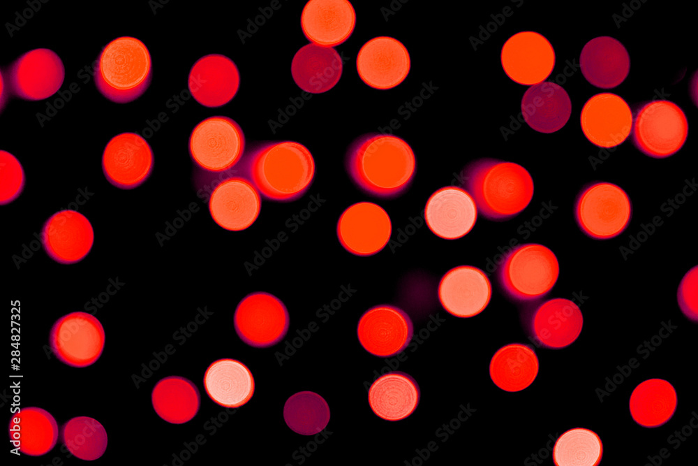 Unfocused abstract red bokeh on black background. defocused and blurred many round light