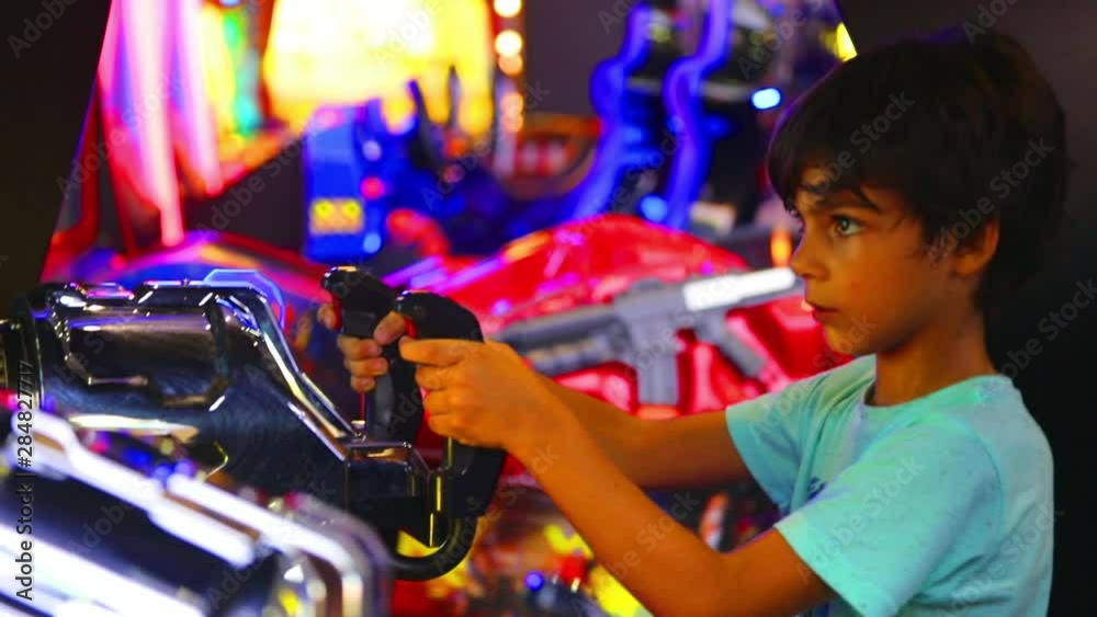 Boy Playing Console Game in Amusement Park Boy Playing Console Game in Amusement Park