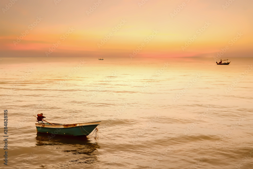 Beautiful dramatic atmosphere of twilight sky and sea with fisherman's boats in summer tropical season.