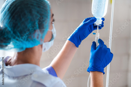 Nurse preparing drop counter to a patient for procedure in hospital