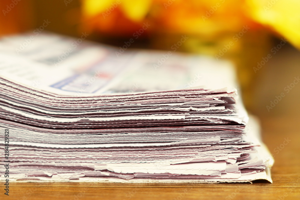 Stack of Newspapers on Wooden Table. Magazines with News Stacked in Pile. Close up view of Tabloid Journals with Headlines and Articles, Focus on Paper. For Business Concept or Background Texture Stack of Newspapers on Wooden Table. Magazines with News Stacked in Pile. Close up view of Tabloid Journals with Headlines and Articles, Focus on Paper. For Business Concept or Background Texture