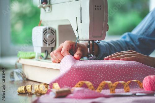 Fotografie Electric sewing machine and different sewing accessories during sewing process