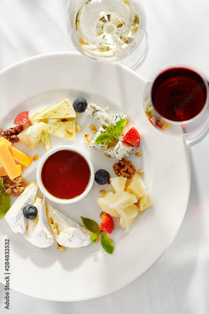 Gourmet, restaurant, delicious dinner food - close up of cheese plate with honey dip and fresh berries Gourmet, restaurant, delicious dinner food - close up of cheese plate with honey dip and fresh berries