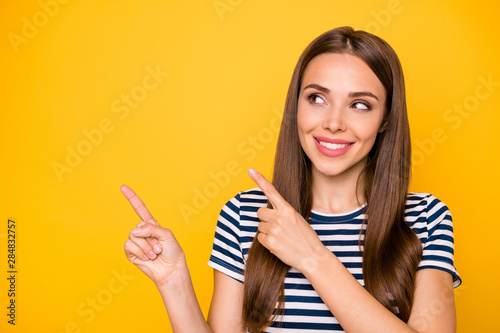 Photo of pretty lady indicating fingers empty space on banner with news wear striped t-shirt isolated yellow background