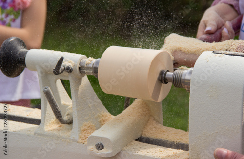 women hands holding a chisel near the lathe