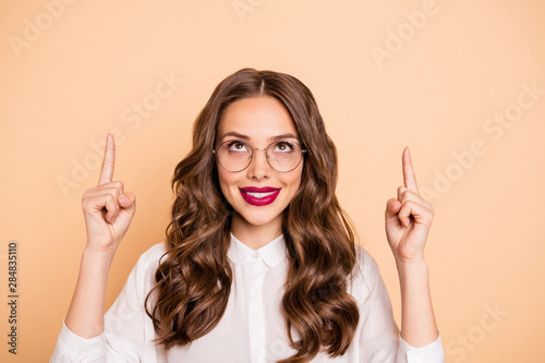 Close-up portrait of her she nice-looking attractive lovely glamorous gorgeous confident cheerful cheery wavy-haired lady pointing two forefingers up ad advert isolated over beige pastel background